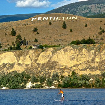 Paddleboarding in front of Penticton Sign on Munson Mountain