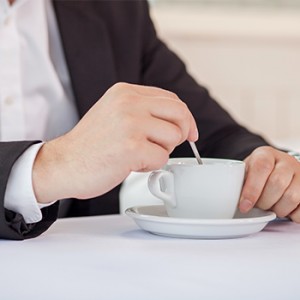 Man in suit stirring coffee during meetings in Penticton BC